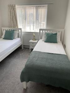 um quarto com 2 camas e uma janela em Seabreeze -modern spacious house with great garden em Lyme Regis