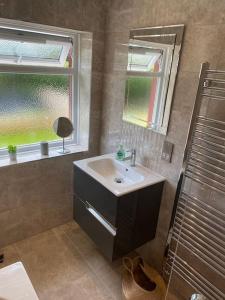 uma casa de banho com um lavatório e uma janela em Seabreeze -modern spacious house with great garden em Lyme Regis