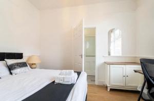 a white bedroom with a bed and a desk at 3 bedroom house with modern interior, close to the Etihad stadium in Manchester