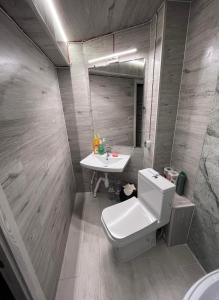 La salle de bains est pourvue de toilettes blanches et d'un lavabo. dans l'établissement Central rooms, à Chişinău