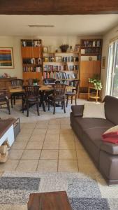 sala de estar con sofá, mesa y sillas en La Maison des Roses en Drachenbronn