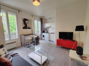 - un salon avec un canapé et une table rouge dans l'établissement Charming Parisian studio!, à Paris