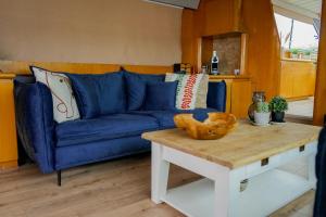 a blue couch in a living room with a table at Yacht Aquamarina vieux port La Rochelle in La Rochelle