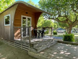 a small cabin with a table on a deck at International Camping Ardèche in Salavas