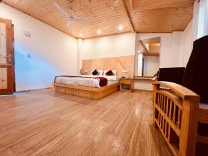 Manali Castle - Wonder Hill في مانالي: غرفة نوم بسرير وسقف خشبي