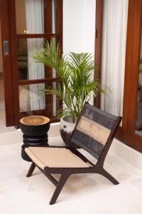 a black chair sitting in a room with a plant at Villa Manis La Bora in Seminyak in Seminyak