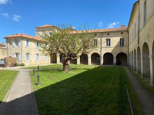 un grand bâtiment avec un arbre en face dans l'établissement Charmant appartement Château d'Oléron, au Château-dʼOléron