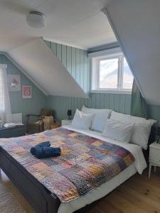 1 dormitorio con 1 cama con edredón en Fjord House, en Grimo