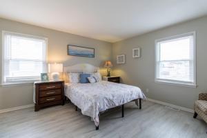 een slaapkamer met een bed en 2 ramen bij Cozy 3BR Home - Steps from the Shore in Brigantine