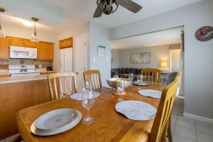 een eetkamer en een keuken met een houten tafel en stoelen bij Cozy 3BR Home - Steps from the Shore in Brigantine