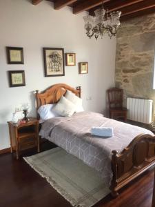 um quarto com uma cama grande e um lustre em Casa de Romaxe em Muros
