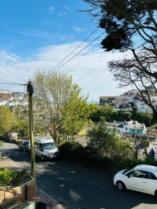 two cars parked in a parking lot in a city at Captain's Nook, Luxurious Victorian Apartment with Four Poster Bed and Private Parking only 8 minutes walk to the Historic Harbour in Brixham