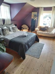 a bedroom with a bed and a cat laying on a couch at Fjord House in Grimo