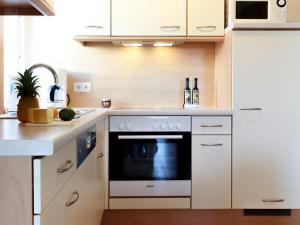 a kitchen with white cabinets and an oven at Reethus Natalie in Zingst