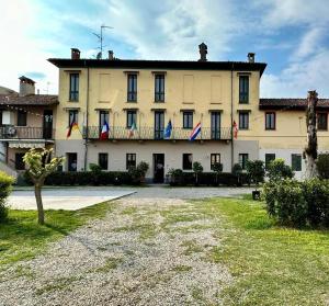 a large building with flags on the front of it at Hotel Duca di Tromello in Tromello