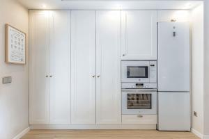 uma cozinha branca com um frigorífico e um micro-ondas em Deluxe Bungalow Sea View em Santa Úrsula