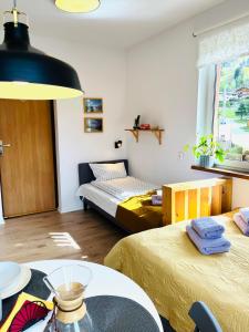 una habitación con 2 camas y una mesa en una habitación en Apartamenty Bieńkula, en Szczyrk