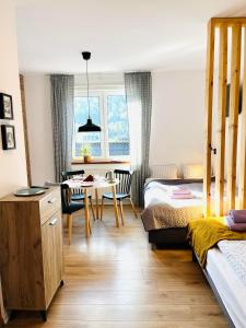 1 dormitorio con 1 cama y comedor con mesa en Apartamenty Bieńkula, en Szczyrk