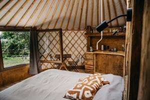 a bedroom with a bed and a window in a yurt at Jurta a Duna-parton in Zebegény
