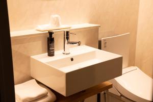 ein weißes Bad mit einem Waschbecken und einem WC in der Unterkunft Ryokan Asakusa Shigetsu in Tokio