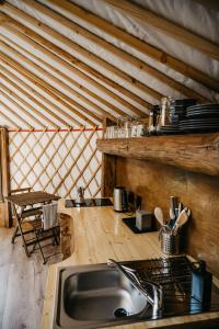 a kitchen with a sink and a wooden ceiling at Jurta a Duna-parton in Zebegény