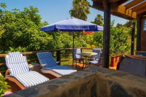 CASA RÚSTICA CON JACUZZI في لاس بالماس دي غران كاناريا: فناء مع كراسي وطاولة مع مظلة