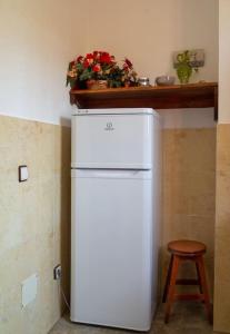 CASA RÚSTICA CON JACUZZI في لاس بالماس دي غران كاناريا: ثلاجة بيضاء في المطبخ مع كرسي