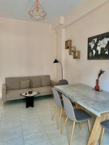 uma sala de estar com um sofá, uma mesa e cadeiras em Athens nice apartment em Atenas