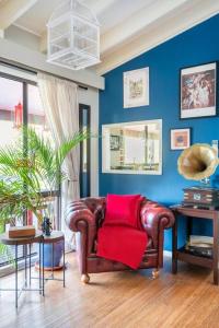 a living room with a leather couch with a red blanket at The Red Cottage in Wentworth Falls