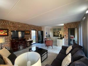 ein Wohnzimmer mit einer Couch und einer Backsteinwand in der Unterkunft SeaBreeze Guest Suite in Kapstadt