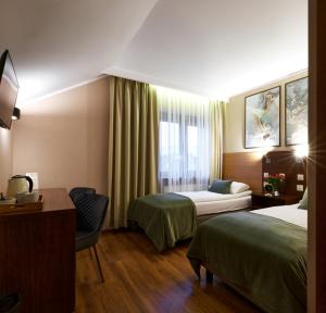 Oborniki ŚląskieにあるRestauracja Perłaのベッド2台とソファが備わるホテルルームです。