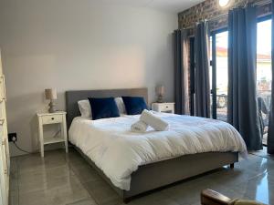 ein Schlafzimmer mit einem großen Bett und blauen Kissen in der Unterkunft SeaBreeze Guest Suite in Kapstadt