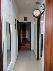un pasillo con un reloj colgando en la pared en Manu's Family Home, en Haridwar