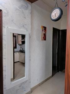 Habitación con espejo y reloj en la pared en Manu's Family Home, en Haridwar