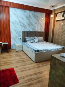 1 dormitorio con 1 cama con una pared grande en Manu's Family Home, en Haridwar