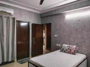 1 dormitorio con 1 cama en una habitación con puerta en Manu's Family Home, en Haridwar