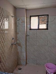y baño con ducha y ventana. en Manu's Family Home, en Haridwar