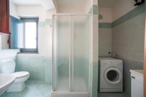 La salle de bains est pourvue de toilettes et d'un lave-linge. dans l'établissement Etna Mare Home, à Riposto