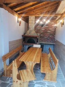 una mesa y bancos en una habitación con chimenea en Family Boutique Residence-Free parking, en Veliko Tŭrnovo