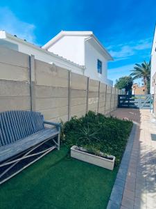 Eine Holzbank steht vor einem Zaun in der Unterkunft SeaBreeze Guest Suite in Kapstadt