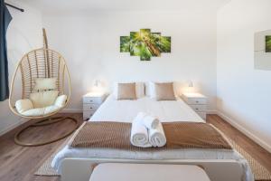 ein Schlafzimmer mit einem Bett mit zwei Stühlen und einer Schaukel in der Unterkunft Silver Coast Apartments Tulip in Atouguia da Baleia