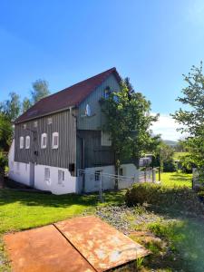 dużą czarno-białą stodołę z ogródkiem w obiekcie Zimmervermietung Leuba w mieście Ostritz