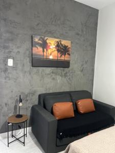 a living room with a black couch and palm trees at Flamengo Home in Rio de Janeiro