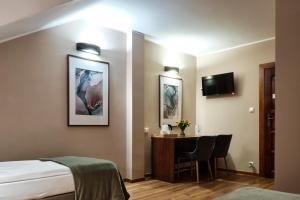Pokój hotelowy z łóżkiem, biurkiem i telewizorem w obiekcie Restauracja Perła w mieście Oborniki Śląskie +4 zdjęcia