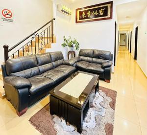 a living room with a leather couch and a coffee table at Rainbow Hotel in Alor Setar