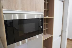 een magnetron in een keuken met houten planken bij TodaStays Luxury Apartments in Lekki Phase 1