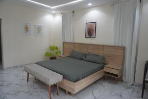 een slaapkamer met een bed en een bank erin bij TodaStays Luxury Apartments in Lekki Phase 1