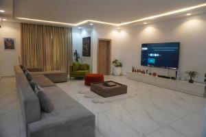 een woonkamer met een grote flatscreen-tv bij TodaStays Luxury Apartments in Lekki Phase 1