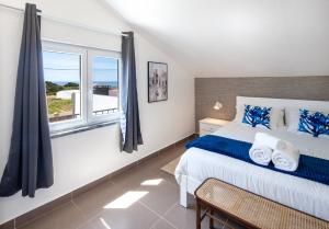 Un dormitorio con una cama grande y una ventana en Silvercoast Apartments - swimming pool & jacuzzi, en Atouguia da Baleia
