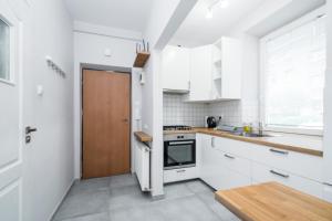 a kitchen with white cabinets and a wooden door at Schindler's Studio WAWELOFTS in Krakow
